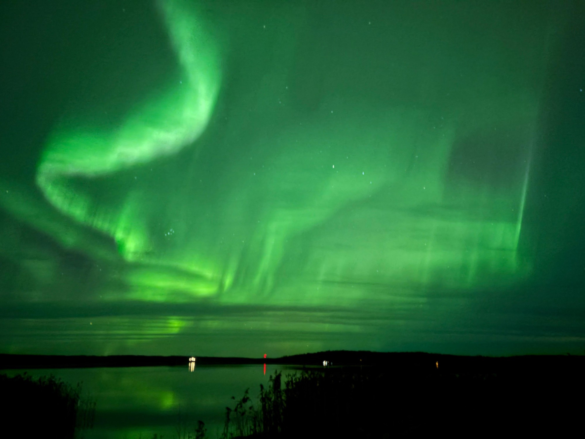 Aurora boreal sobre un lago en una de las localizaciones de Rovaniemi
